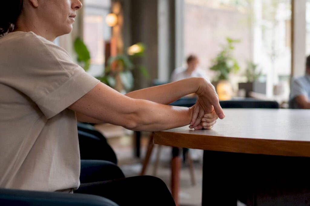 Hands performing wrist stretch at ergonomic desk