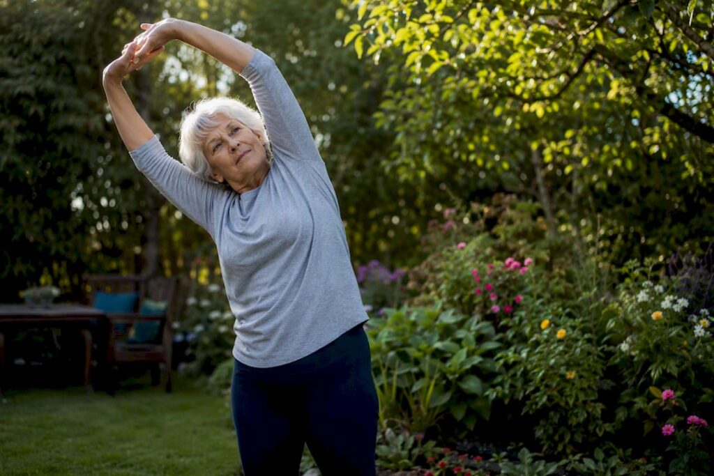 Senior gently stretching arms at home